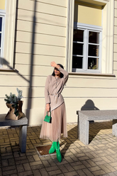 a lady in an asymmetrical top, a brown tulle pleated skirt and a pair of green boots
